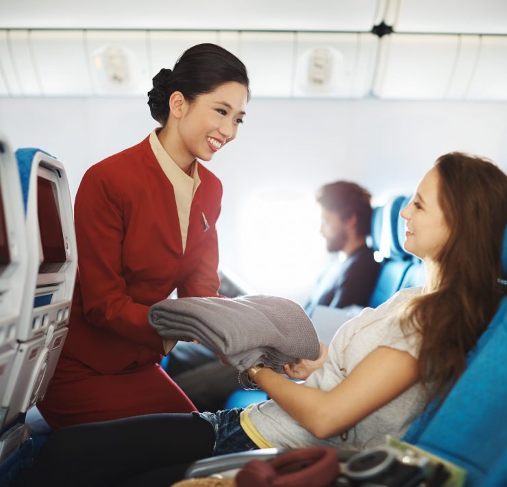 Cathay Pacific - Flight attendant serves a passenger - Cathay Pacific set to cut jobs in January 2017 - Will cabin crew be included