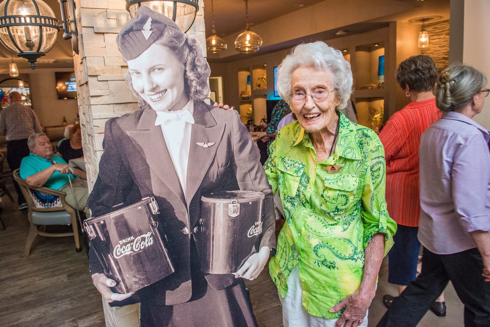 an older woman standing next to a cardboard cutout of a woman