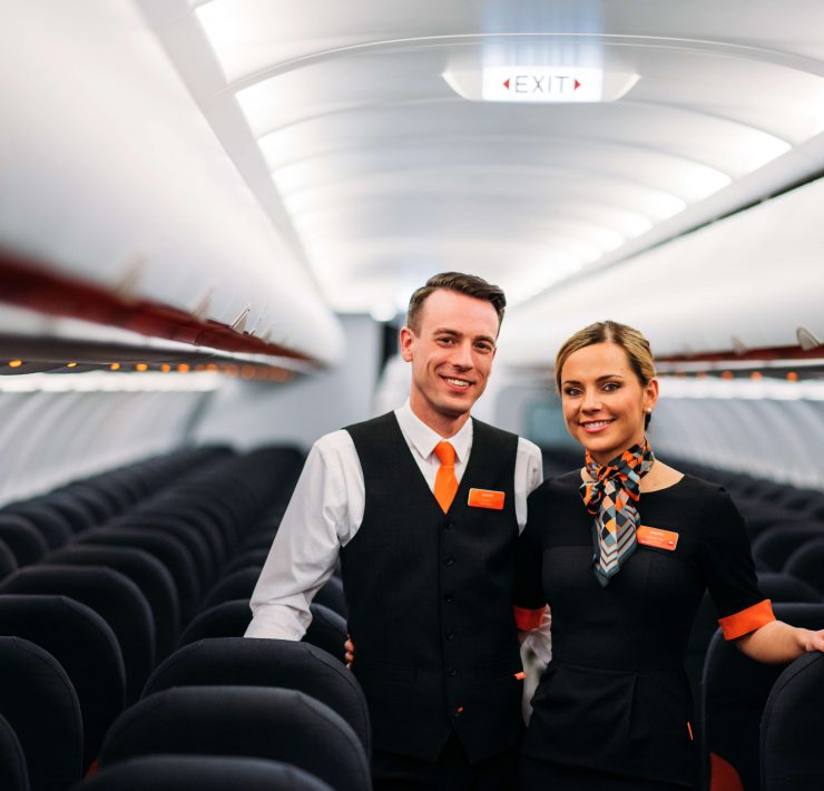 a man and woman standing in an airplane
