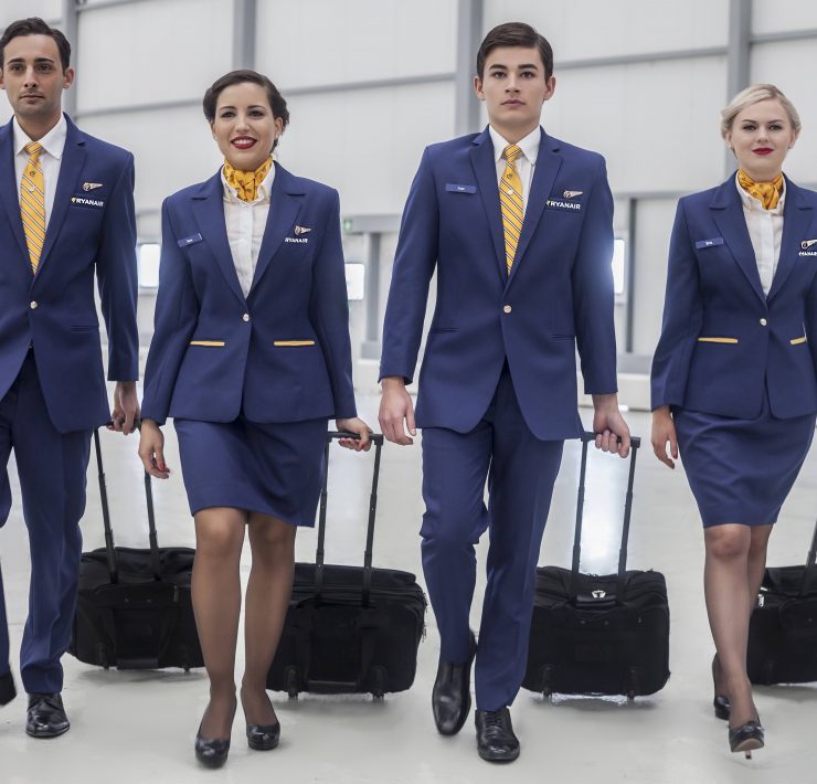 a group of people in blue suits with luggage