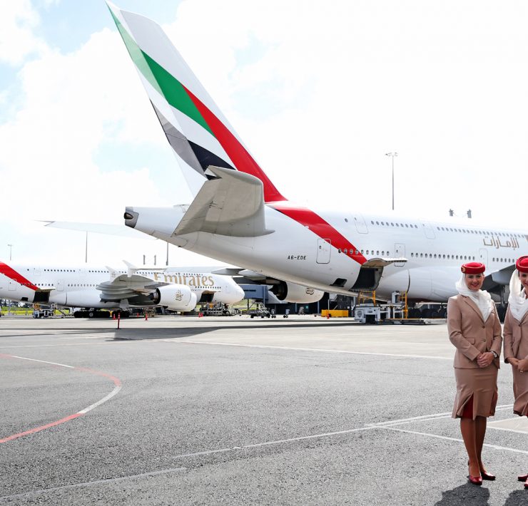 two people standing in front of airplanes