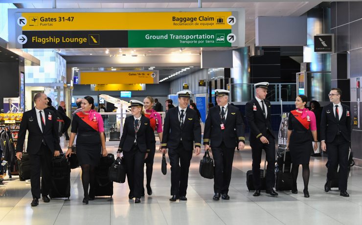 a group of people in uniform walking with luggage