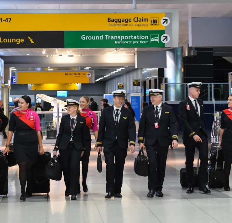 a group of people in uniform walking with luggage