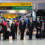 a group of people in uniform walking with luggage