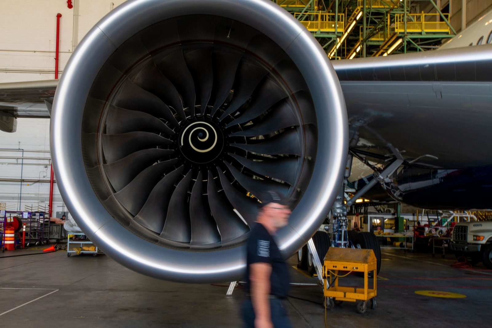 a man walking past a large jet engine