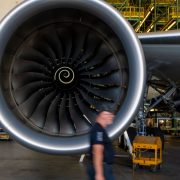 a man walking past a large jet engine