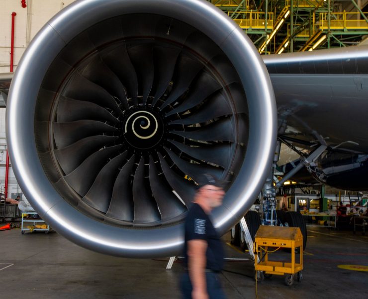 a man walking past a large jet engine