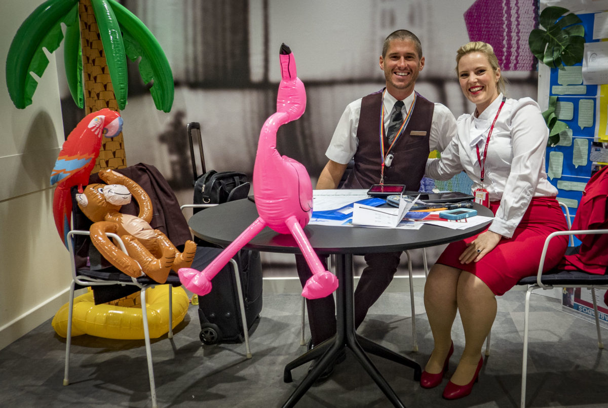 a man and woman sitting at a table with balloons