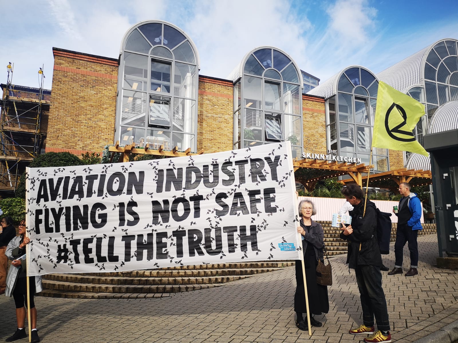 a group of people holding a sign outside a building