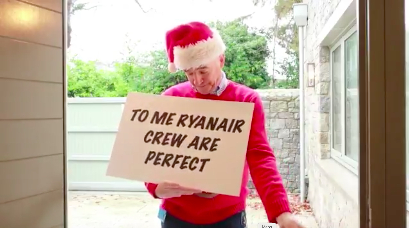 a man in a red sweater and santa hat holding a sign