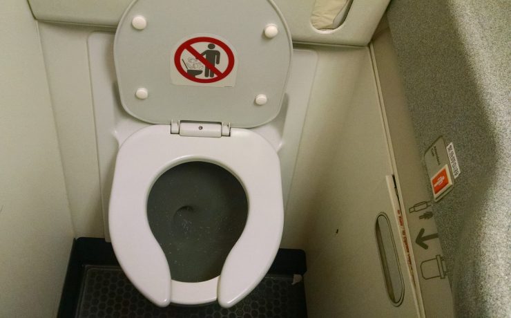 a toilet with a sign on the lid