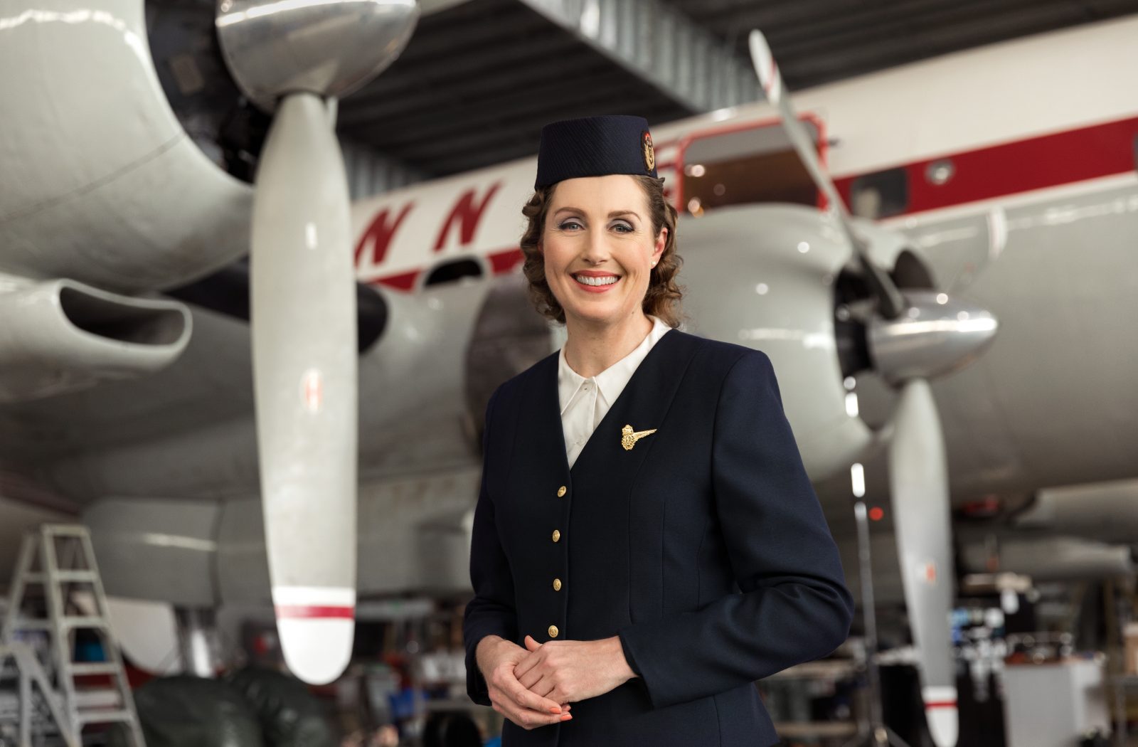 a woman in uniform standing in front of a plane