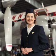 a woman in uniform standing in front of a plane