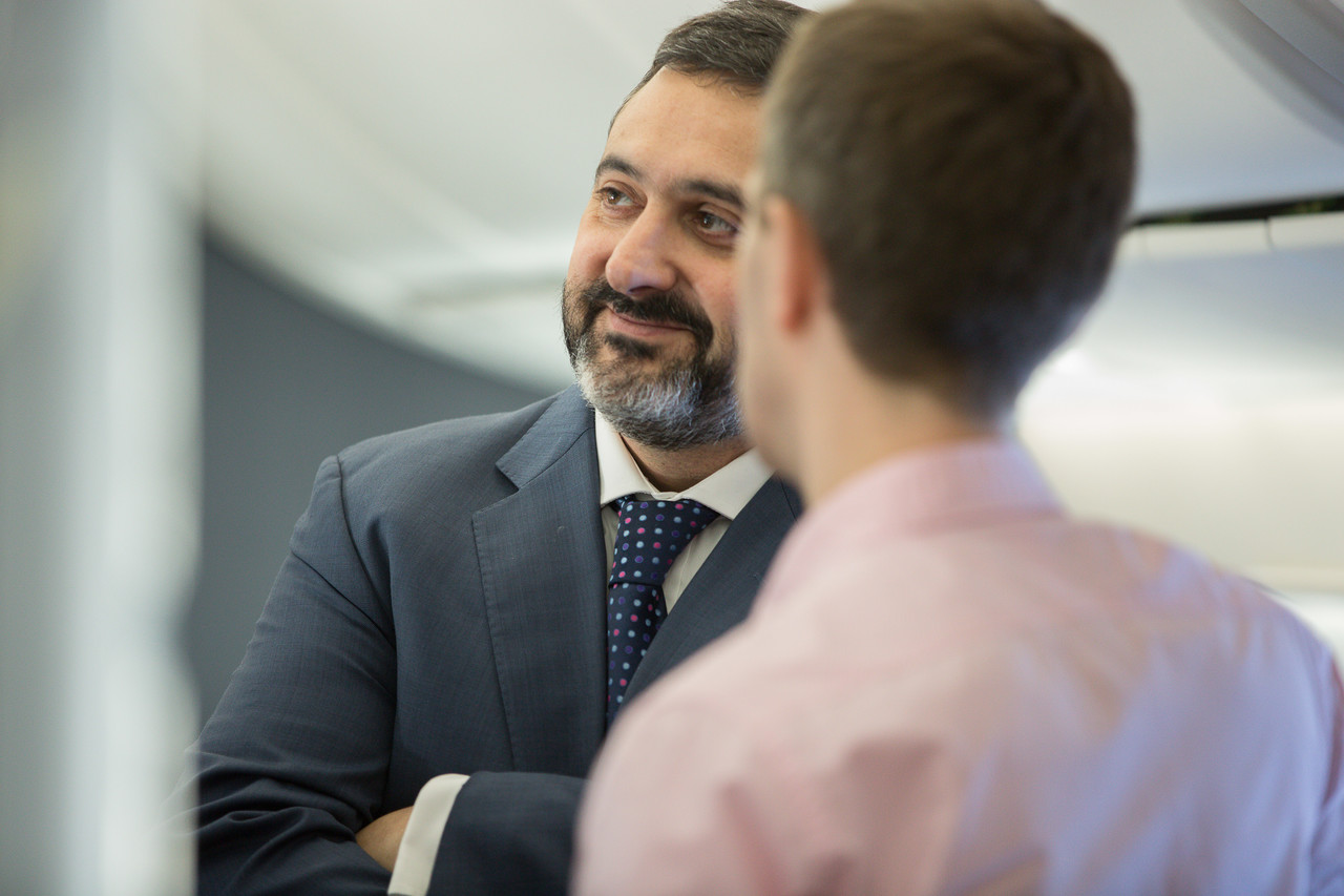 a man in a suit and tie talking to another man