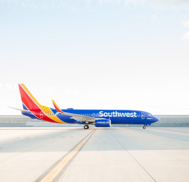 a blue airplane on a runway
