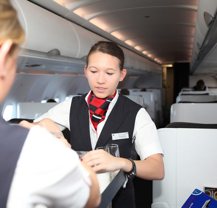 a woman serving drinks on an airplane