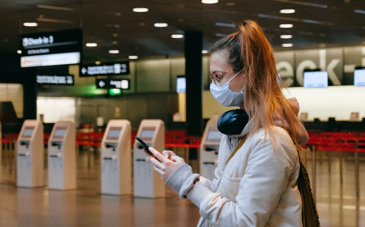 a woman wearing a mask and holding a phone