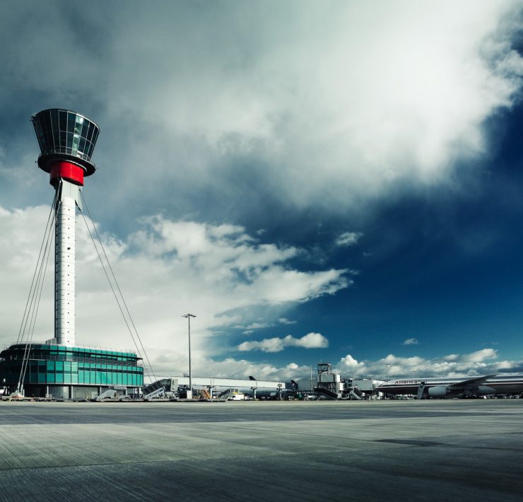 a tower with a building and airplanes in the background