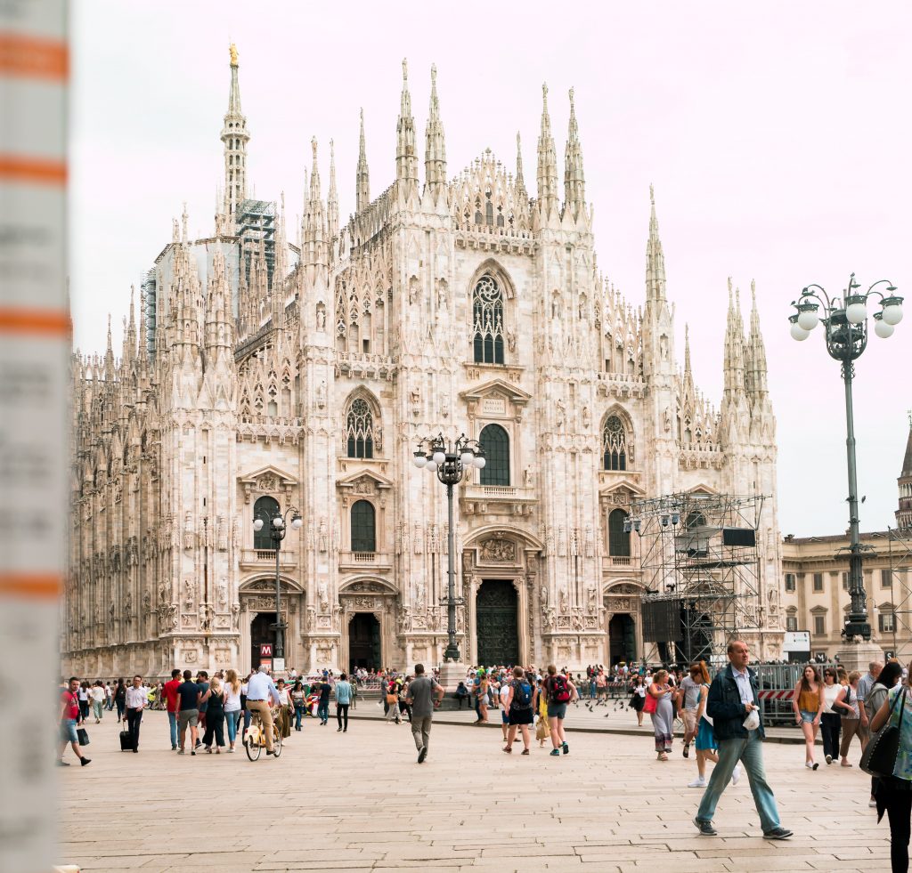 a large building with many people walking around with Milan Cathedral in the background