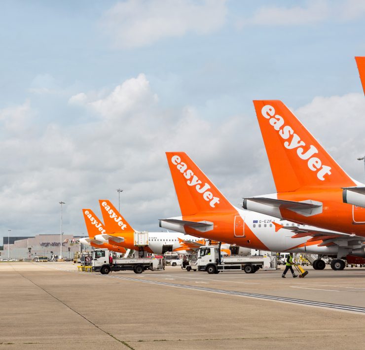 a group of orange and white airplanes parked on a runway