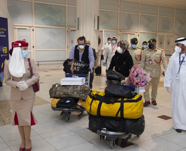 a group of people wearing face masks and standing in a hallway