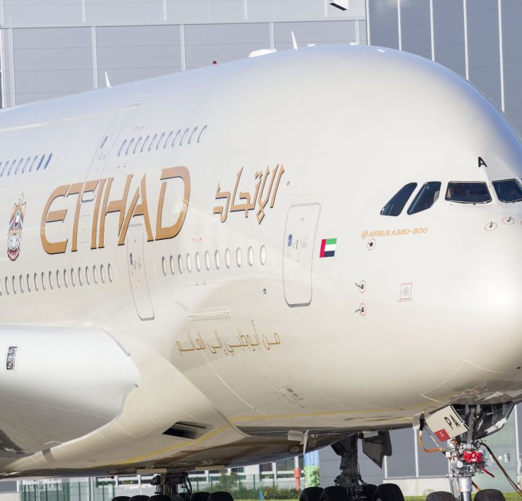 a large white airplane with gold lettering