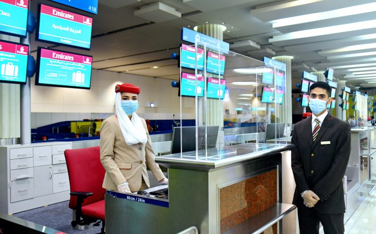 a man and woman wearing face masks at a check-in counter