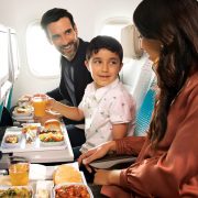 a man and woman sitting in an airplane eating food