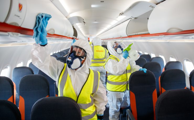 people in protective gear on an airplane