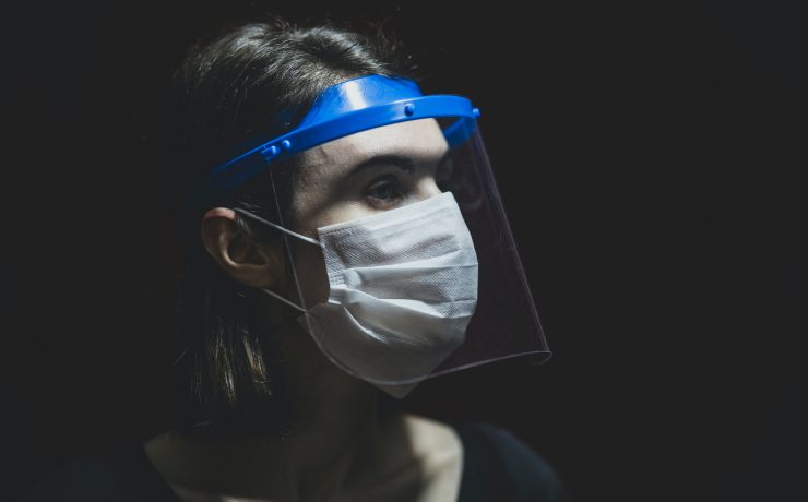 a woman wearing a face shield and a mask