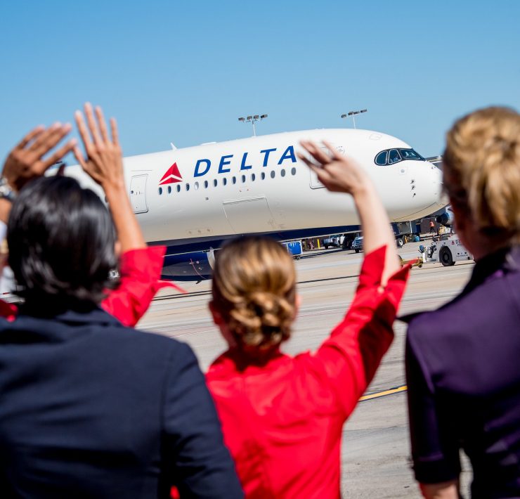 a group of people waving at an airplane