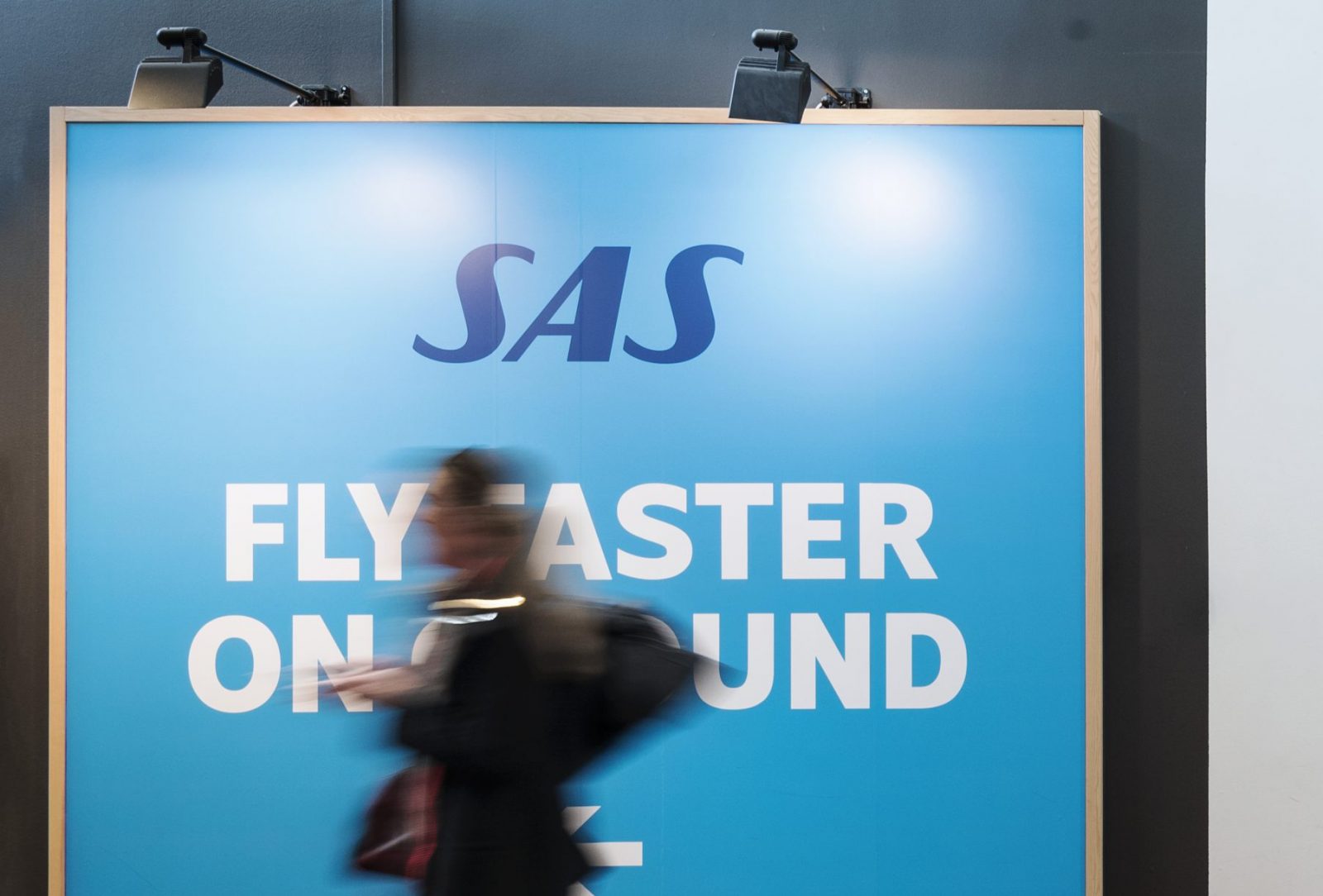 a blurry image of a woman walking in front of a large sign