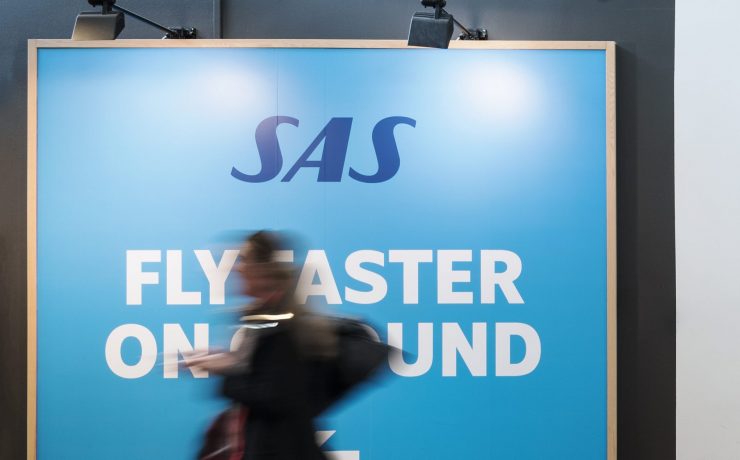 a blurry image of a woman walking in front of a large sign