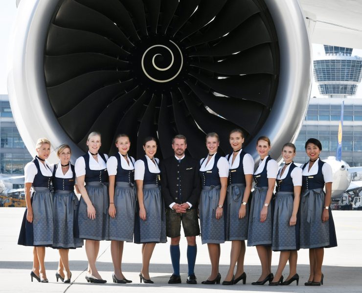 a group of people standing in front of a large jet engine