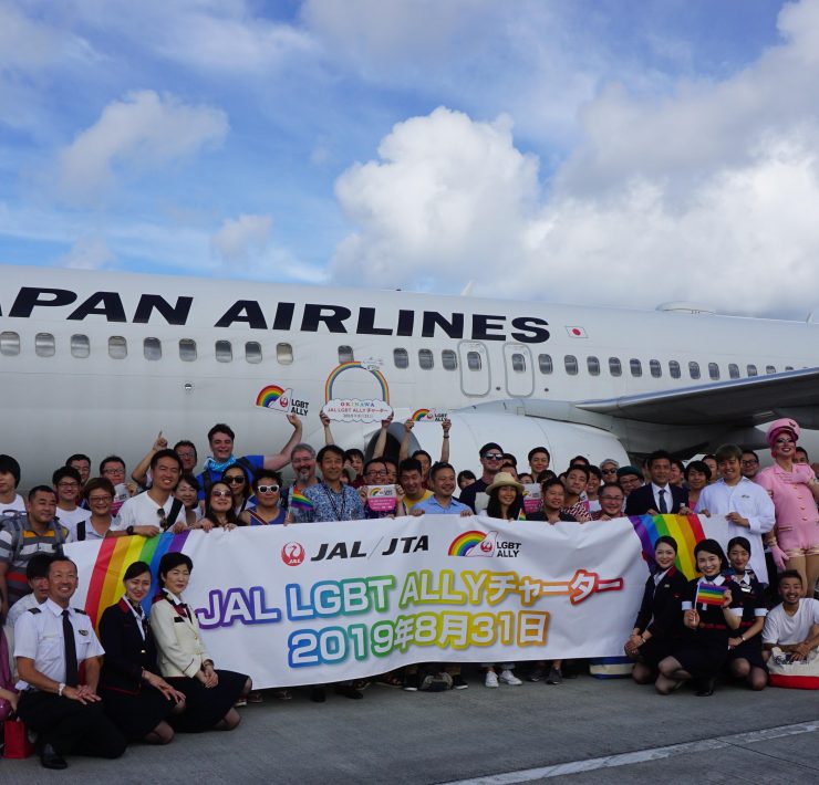 a group of people posing for a photo in front of an airplane