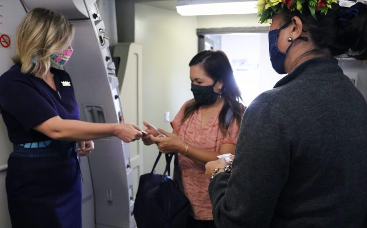 a woman wearing a mask and a flower crown standing in a room with a machine