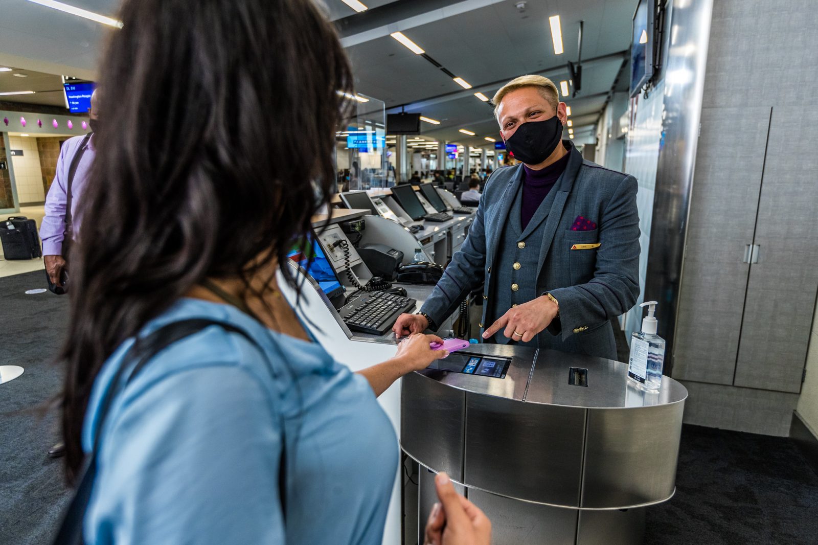 a man wearing a face mask and standing at a counter