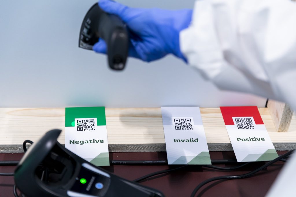 a person wearing a protective suit and gloves holding a barcode scanner