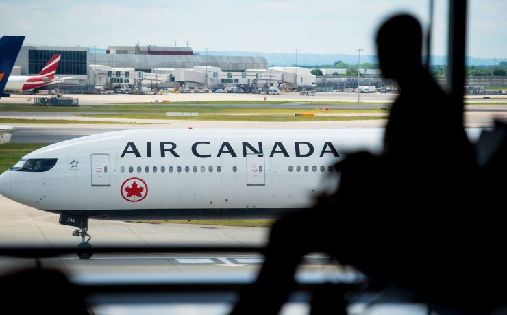 a person sitting in a window looking at an airplane