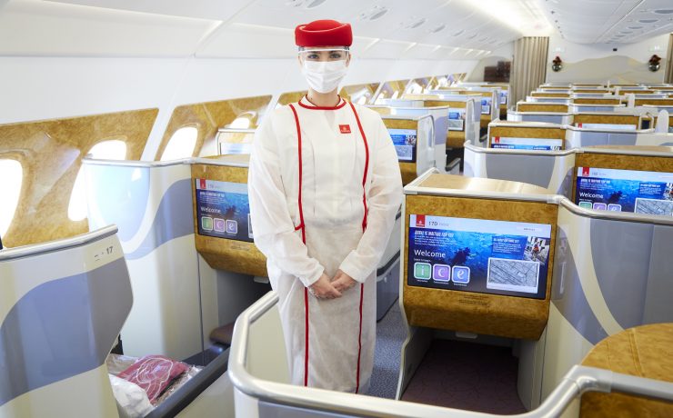 a person in a white suit and mask standing in an airplane