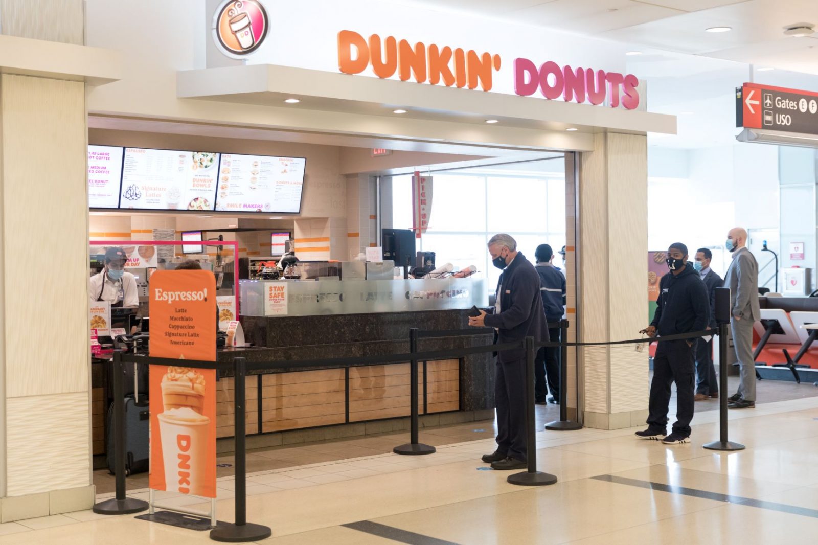 people standing in line at a dunkin donuts restaurant