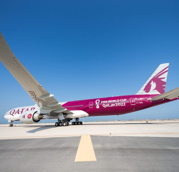 a large pink and white airplane on a runway