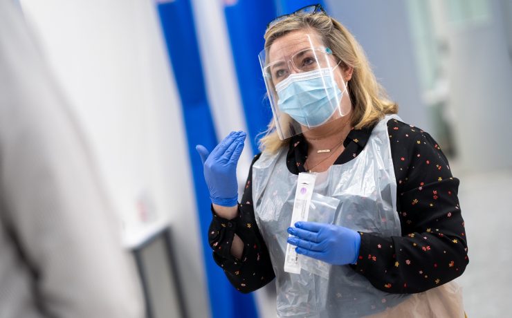 a woman wearing a face shield and gloves