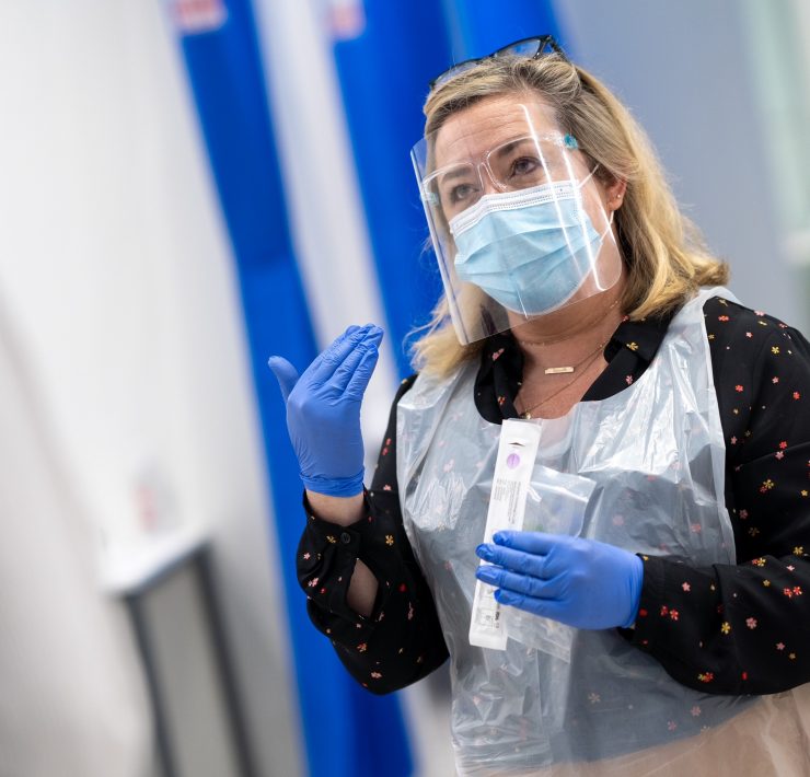 a woman wearing a face shield and gloves