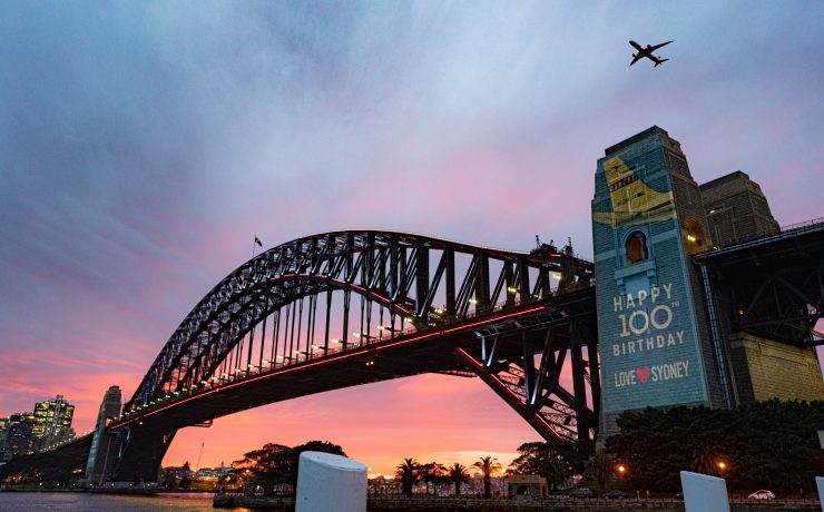 a plane flying over a bridge