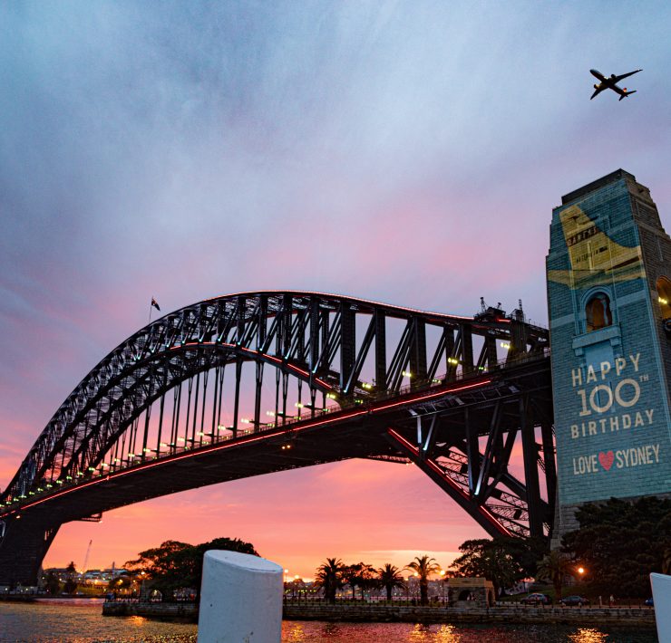 a plane flying over a bridge