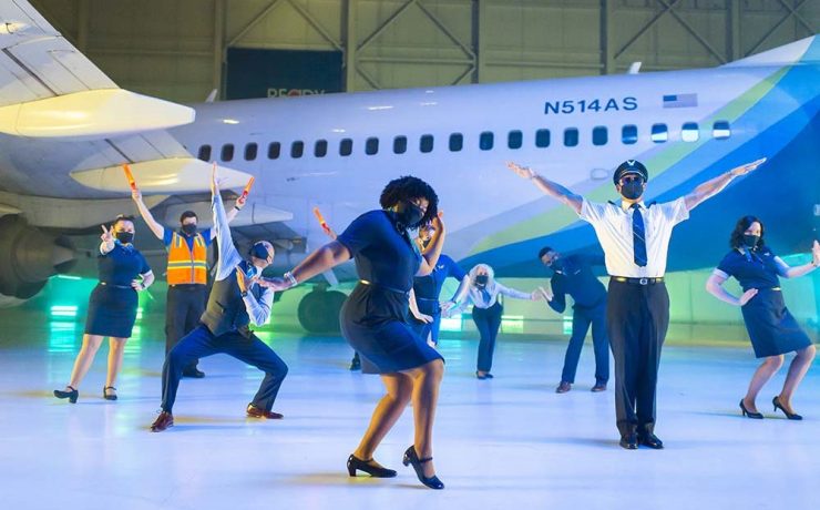 a group of people dancing in front of a plane