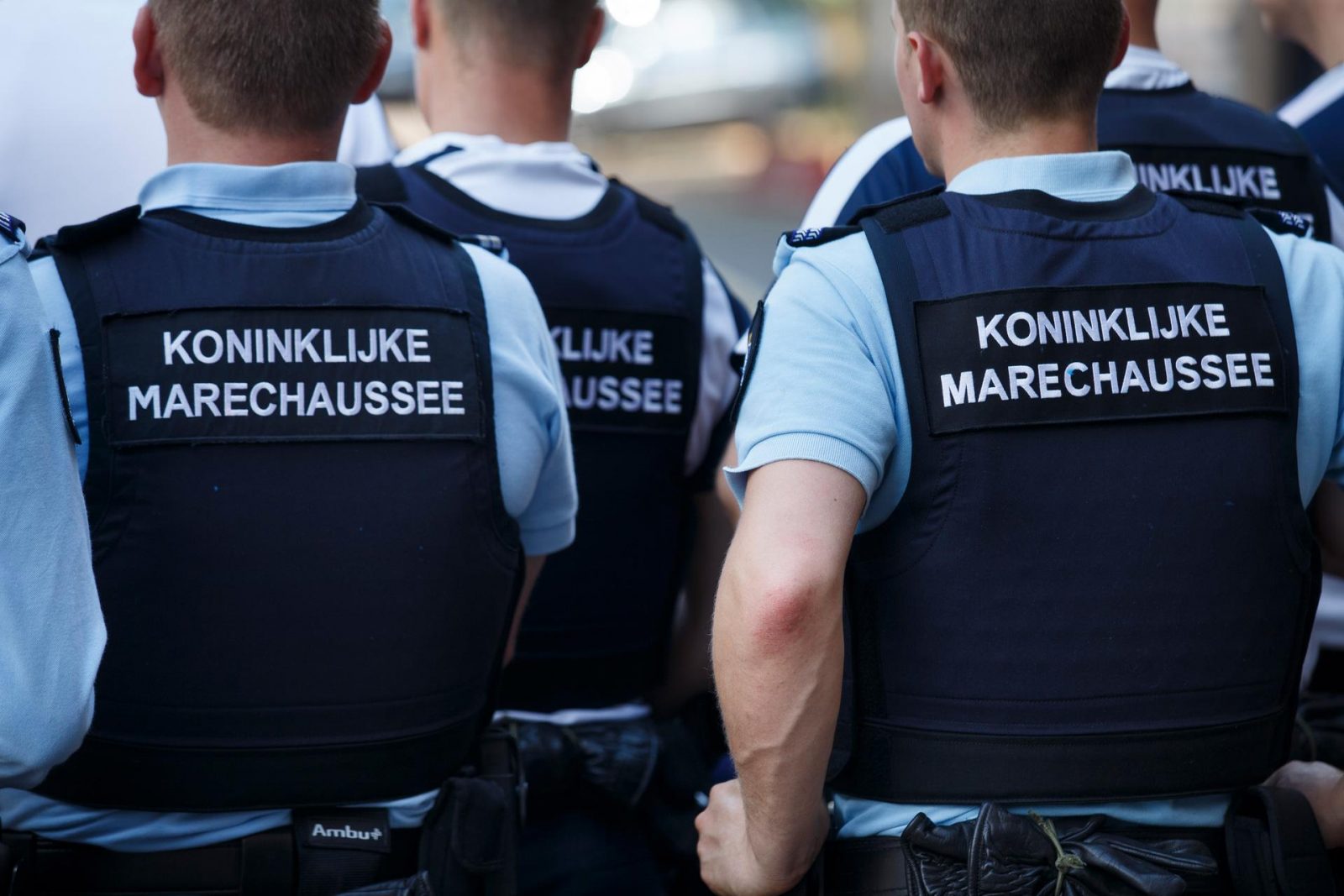 a group of men in blue vests