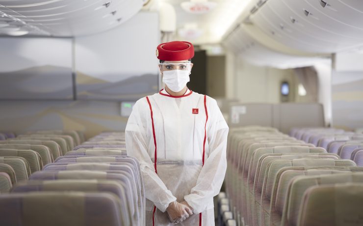a person in a white uniform and mask standing in a row of seats