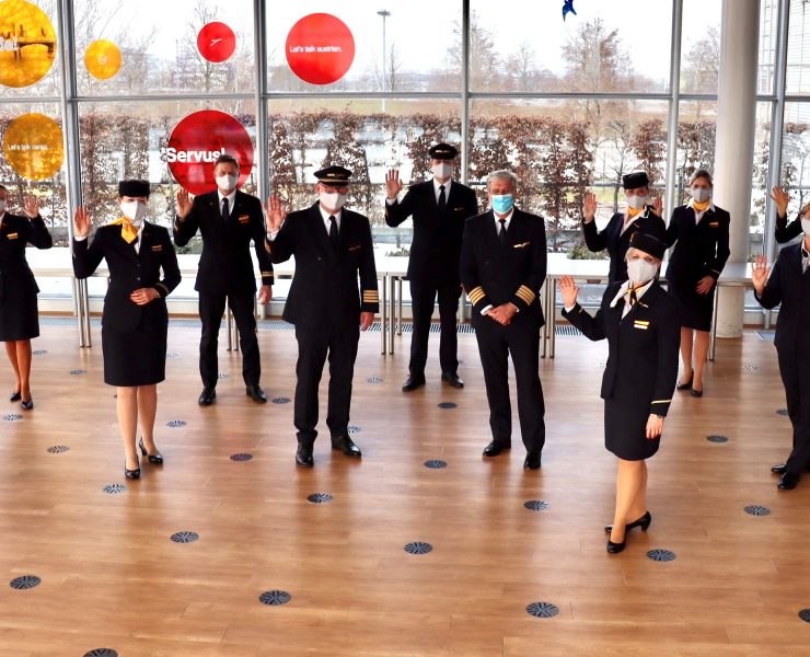 a group of people wearing face masks and standing in a room